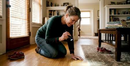 Homeowner inspecting hardwood floor quality