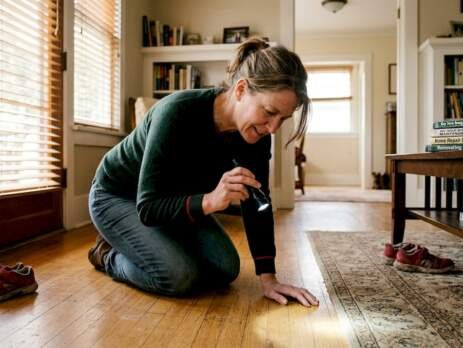 Homeowner inspecting hardwood floor quality