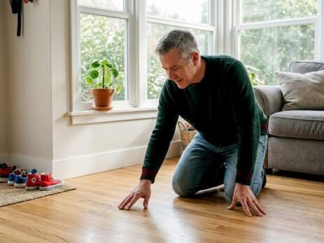 Homeowner inspecting hardwood floors in living room