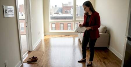 Manager inspecting hardwood floors in rental