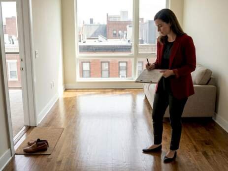 Manager inspecting hardwood floors in rental